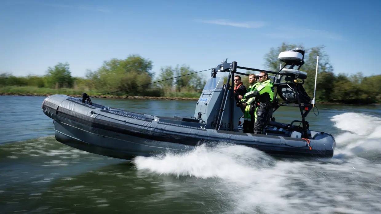 3 man staan op een rubberenboot van de marechaussee