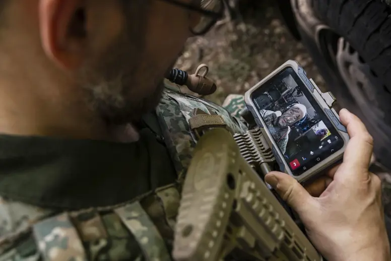 Een militair te velde werkt op een mobiel device.