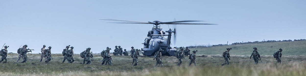 Een helikopter op de grond met er omheen een groep militairen.