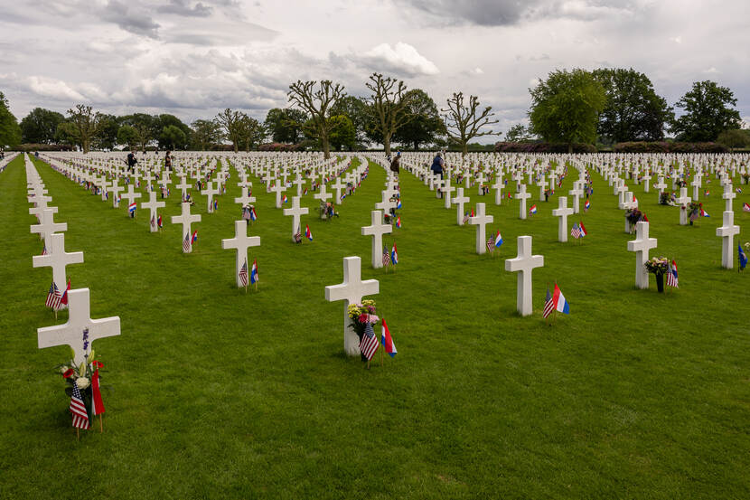 Vele witte kruizen met vlaggetjes ervoor op de Amerikaanse begraafplaats Margraten.