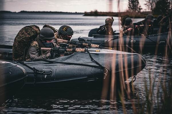 Oekraïense mariniers in rubberboot, met geweer in aanslag