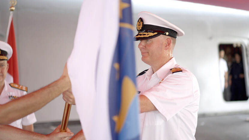 Nieuwe commandant ontvangt vlag tijdens commando-overdracht.