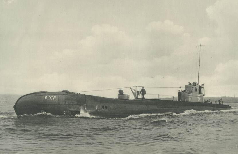 De onderzeeboot Hr.Ms. KXVI varend op zee, terwijl een man over het dek loopt.