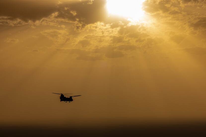 Chinook-transporthelikopter bij ondergaande zon.