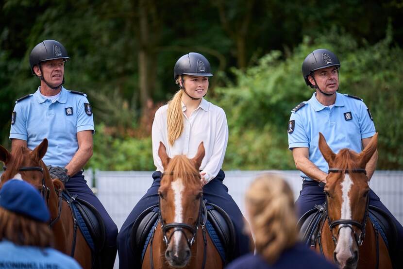 Prinses Amalia te paard, geflankeerd door marechaussees