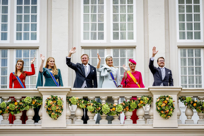 De koninklijke familie staat op het balkon.