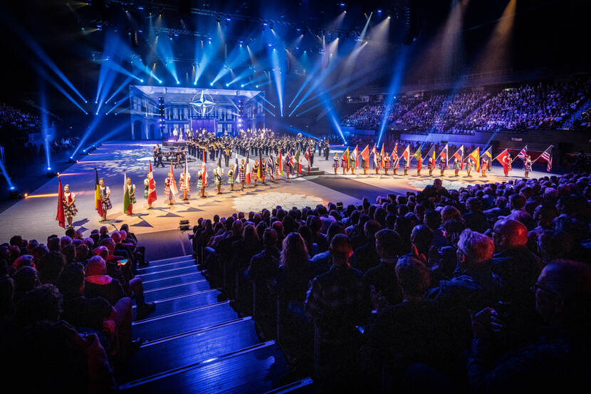 Over de hoofden van de bezoekers zicht op de vloer met daarop danseressen tijdens de Nationale Taptoe.