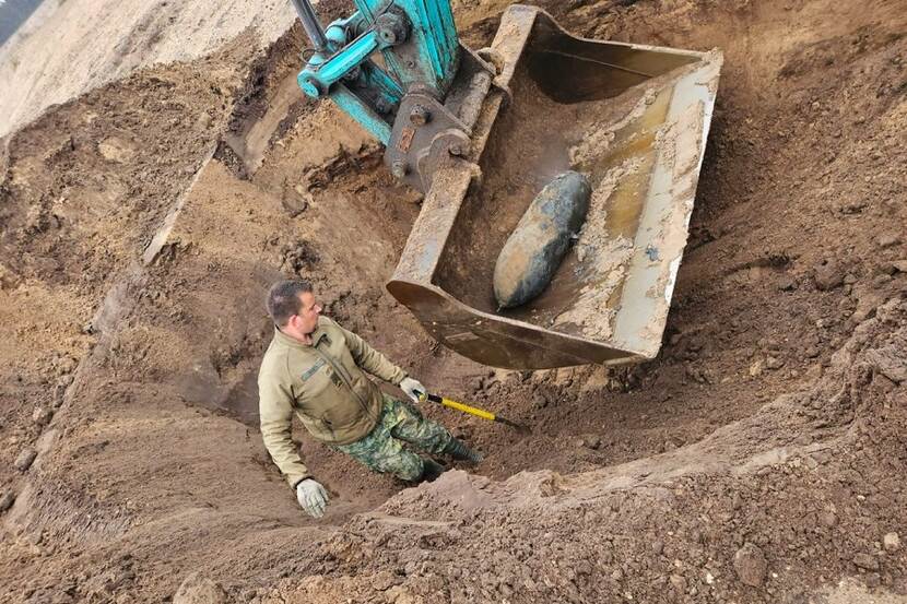 Militair houdt zicht op bom die met shovel verwijderd wordt