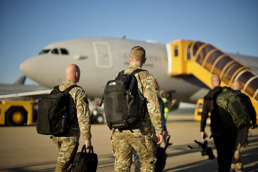 Militairen op weg naar een vliegtuig.