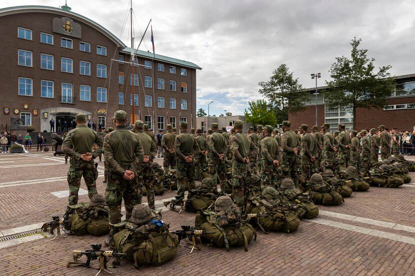 Militairen op de rug gezien voor een kazerne.