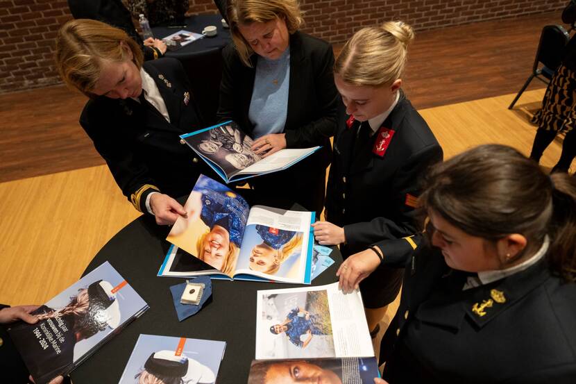 Vrouwen van de marine bladeren door een boek.