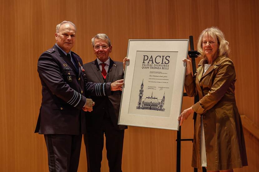 Generaal Eichelsheim krijgt plaquette uitgereikt door 2 juryleden.