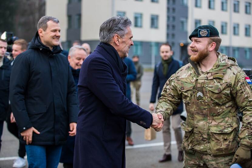 Premier Schoof schudt hand met Nederlandse militair, met links de Litouwse premier Gintautas Paluckas.