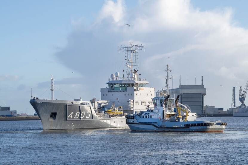 Een marineschip vertrekt uit de haven.