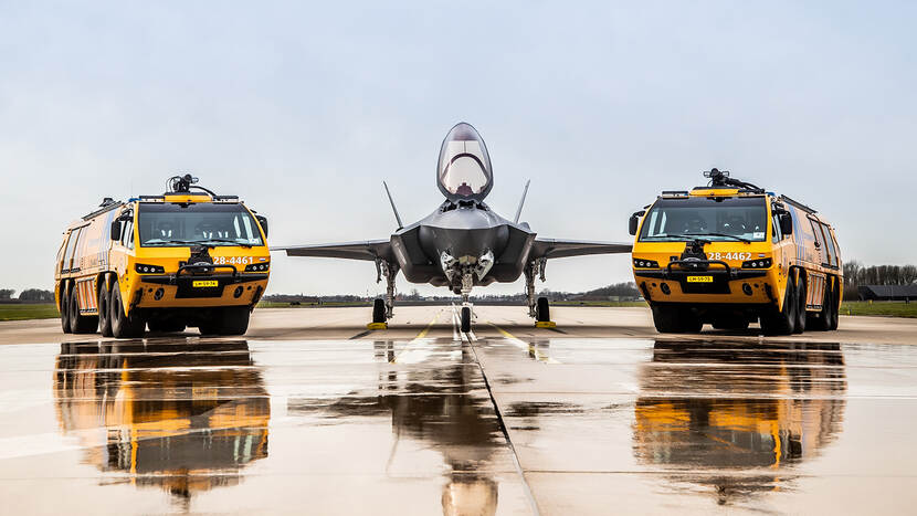 2 gele brandweerwagens met in het midden een F-35