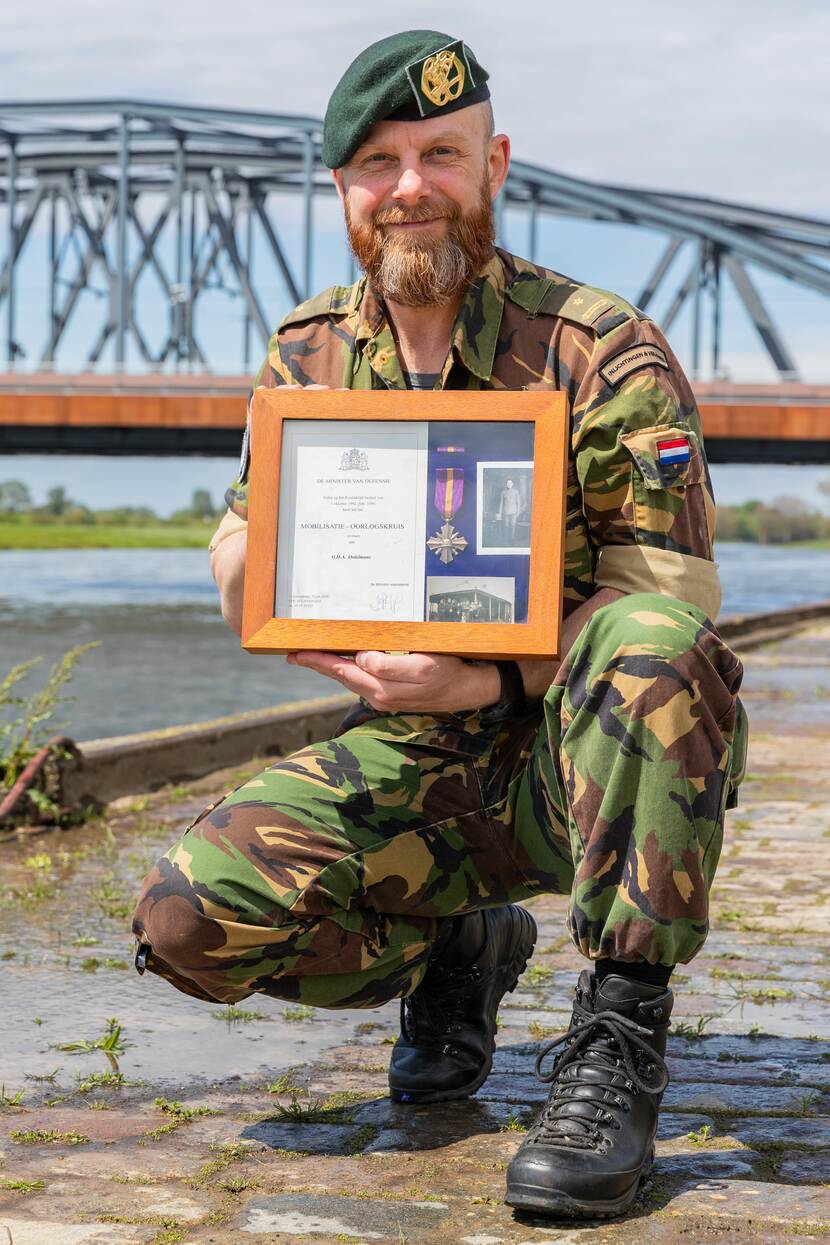 Militair voor de Oude IJsselbrug met mobilisatiekruis van zijn opa.