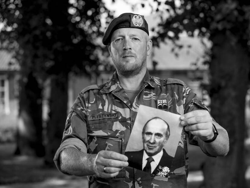 Militair houdt foto van zijn opa omhoog.