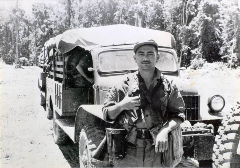 Zwart-wit foto van militair voor een truck.