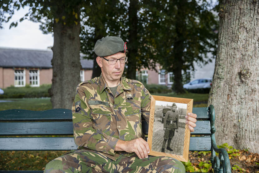 Militair kijkt naar foto van opa.