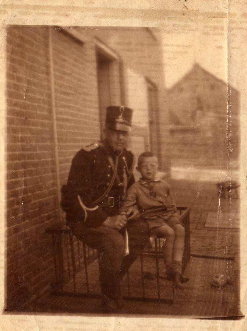 Opa Meulenberg in uniform marechaussee met kind op de foto.
