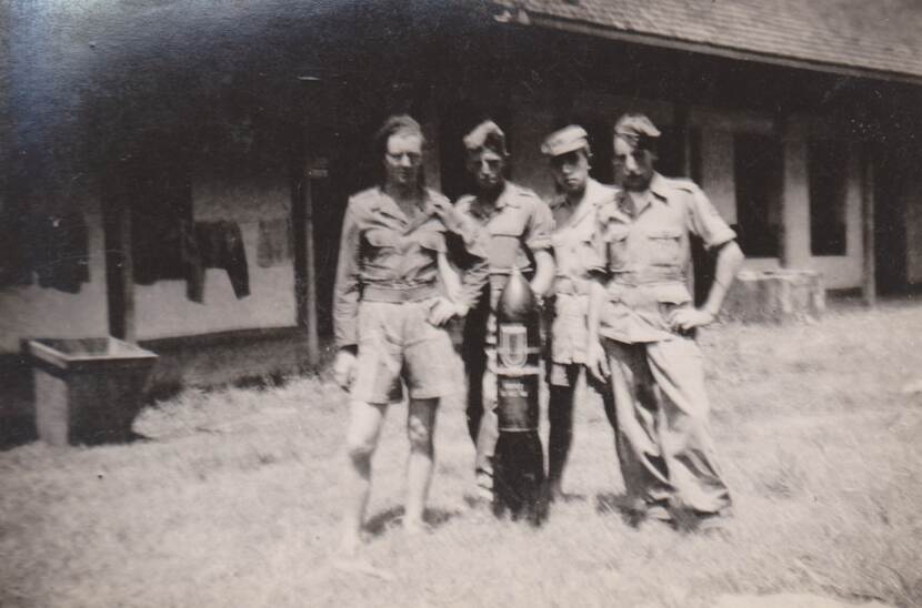 Oude foto: 4 militairen poseren met een vliegtuigbom.