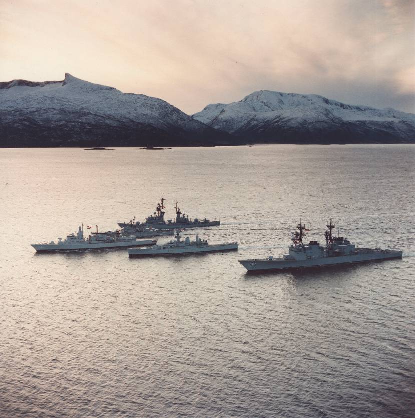 Foto uit 1986. Fregat Hr. Ms. Witte de With als eenheid van de Stanavforlant (Standing Naval Force Atlantic) op zee voor besneeuwde bergen.