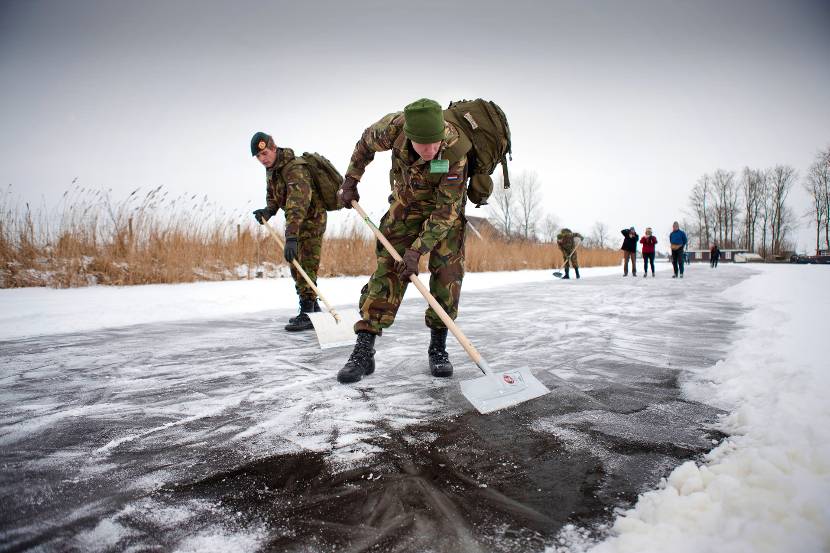 Militairen van 43 Gemechaniseerde Brigade helpen met sneeuwschuiven op de Elfstedentochtroute in de buurt van Woudsend (8 februari 2012).