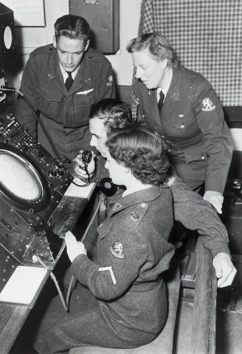 Vrouwelijk en mannelijke militairen kijken op een radar.