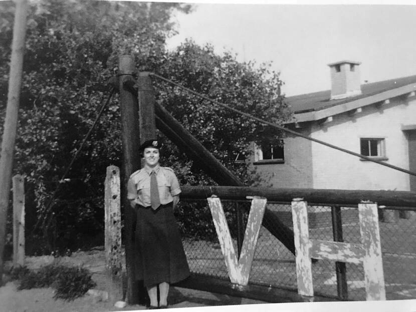 Militair van het Vrouwen Hulpkorps bij een hek