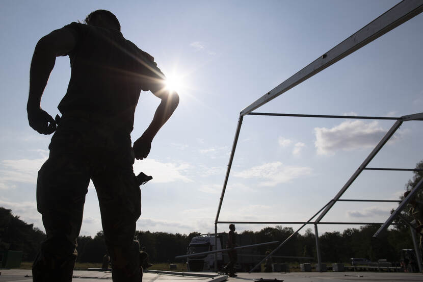 Militairen bouwen een tent op.