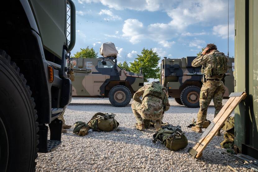 mariniers die hun helm opzetten in de nabijheid van enkele Bushmasters.